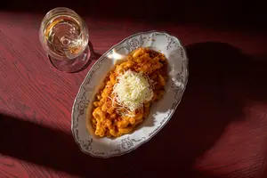 Těstoviny se sýrem a sklenkou bílého vína v restauraci Biskup.